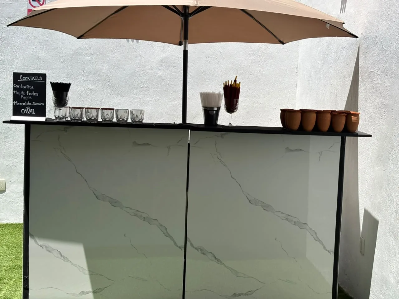 Detalle de la barra de mármol con vasos escarchados, jarritos y popotes